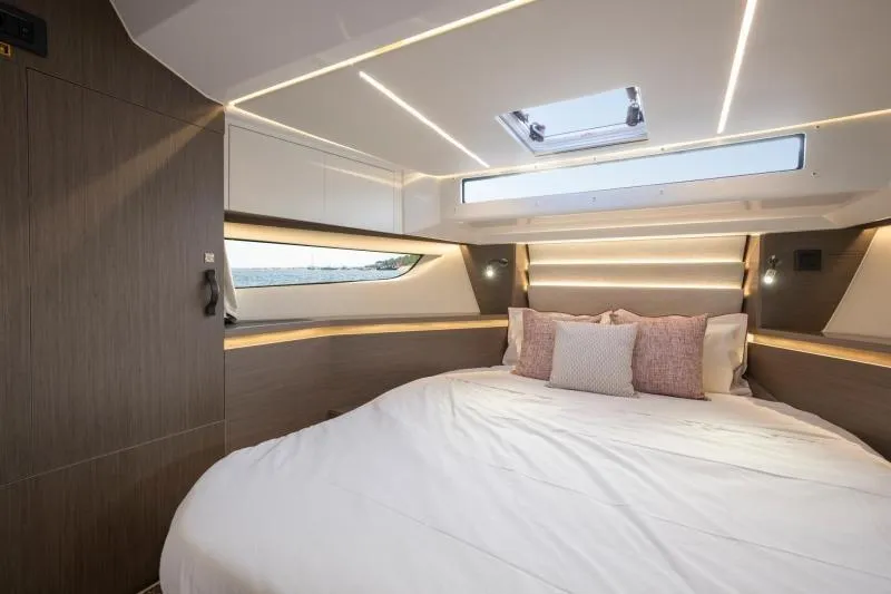 Slide: The Image of Luxurious cabin interior of 2026 Jeanneau NC 1295 Coupe with modern lighting and bedding. - 28