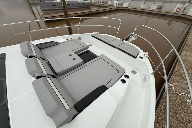 Slide: The Image of 2026 Jeanneau NC 1295 Coupe boat with sleek deck seating in a marina setting. - 36