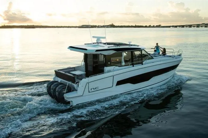 Slide: The Image of 2026 Jeanneau NC 1295 Coupe cruising on calm waters at sunset. - 4
