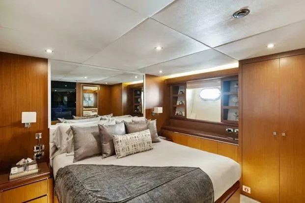 Slide: The Image of Luxurious bedroom interior on 2006 Tecnomar 35 Nadara yacht, featuring elegant wood paneling. - 15