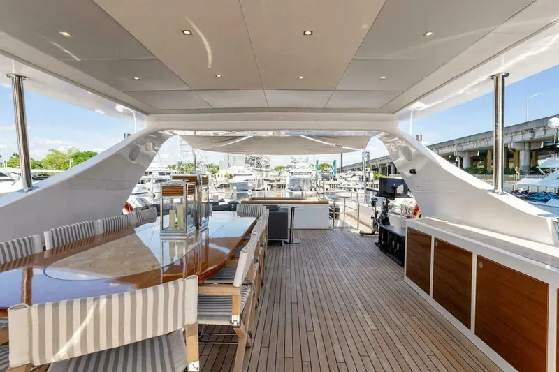 Slide: The Image of Luxurious 2006 Tecnomar 35 Nadara yacht deck with elegant dining area and marina view. - 4