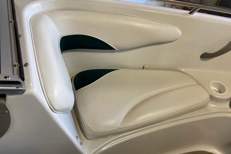 Slide: The Image of 2004 Crownline 192 BR boat interior seating with white upholstery and cup holder. - 16