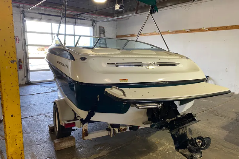 Slide: The Image of 2004 Crownline 192 BR boat in a garage, rear view with trailer. - 2
