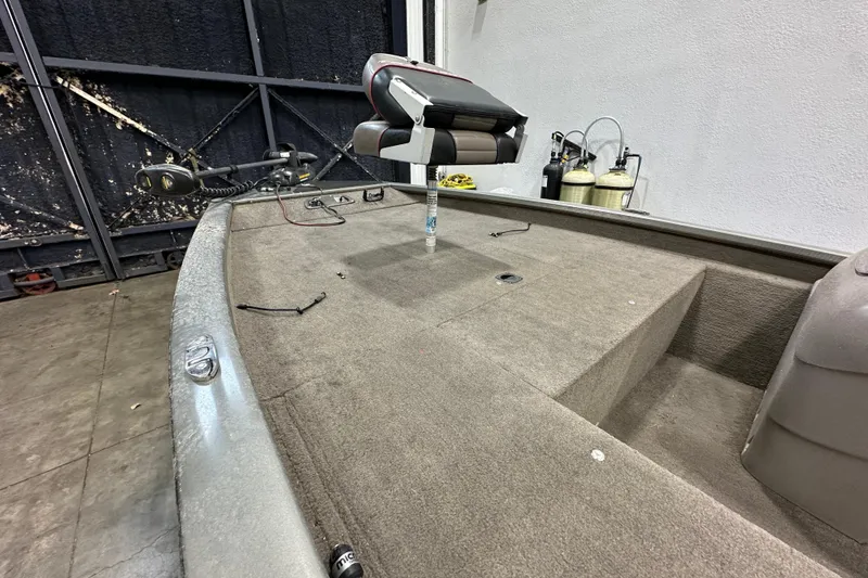 Slide: The Image of 2004 Bass Tracker 175 boat interior with carpeted deck and fishing seat. - 5