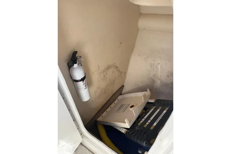 Slide: The Image of Storage compartment in a 2005 Sea Ray 290 SLX with fire extinguisher and equipment. - 3