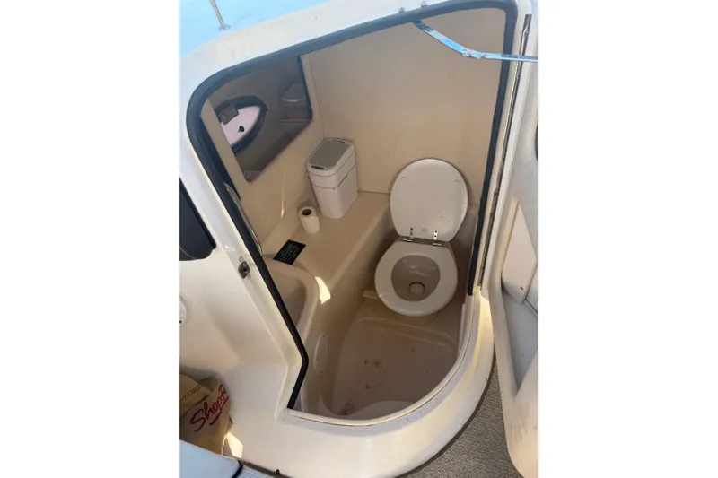 Slide: The Image of 2005 Sea Ray 290 SLX boat bathroom interior with toilet and storage. - 4