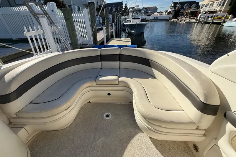 Slide: The Image of 2005 Sea Ray 290 SLX boat with spacious curved seating at a marina. - 7