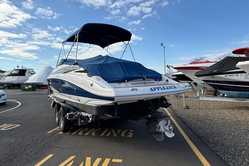 Slide: The Image of 2013 Crownline Eclipse E6 boat with cover, parked in marina under blue sky. - 1