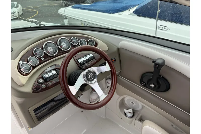 Slide: The Image of 2013 Crownline Eclipse E6 boat dashboard with gauges, steering wheel, and controls. - 10