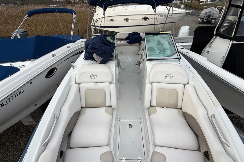 Slide: The Image of 2013 Crownline Eclipse E6 boat with white seating and blue covers, docked among other boats. - 21