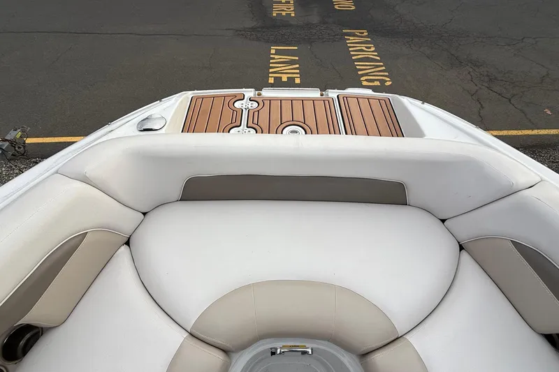 Slide: The Image of 2013 Crownline Eclipse E6 boat interior with cushioned seating and wooden deck. - 23