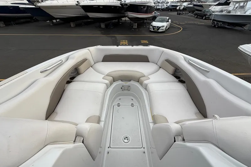 Slide: The Image of 2013 Crownline Eclipse E6 boat interior with spacious seating and storage, parked in a marina. - 24