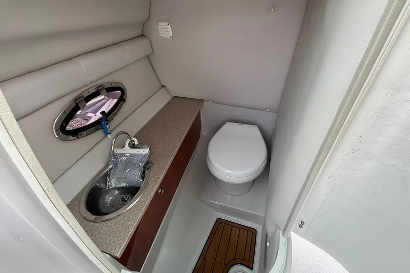 Slide: The Image of 2013 Crownline Eclipse E6 boat bathroom with sink, toilet, and porthole window. - 26