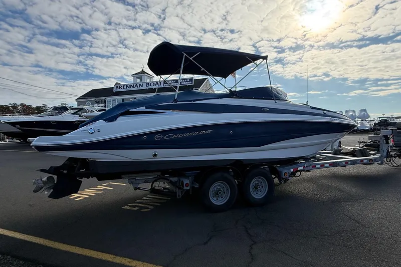 Slide: The Image of 2013 Crownline Eclipse E6 boat on trailer at marina, under a partly cloudy sky. - 4