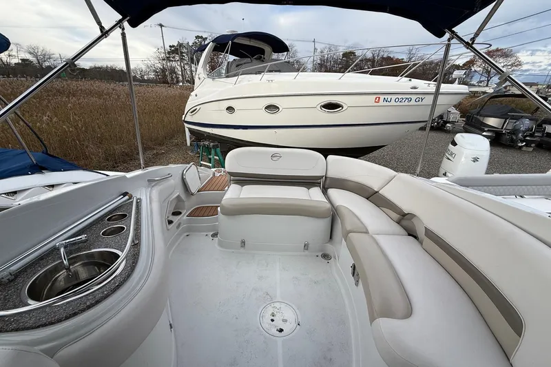 Slide: The Image of 2013 Crownline Eclipse E6 boat interior with seating and sink, docked near another boat. - 6