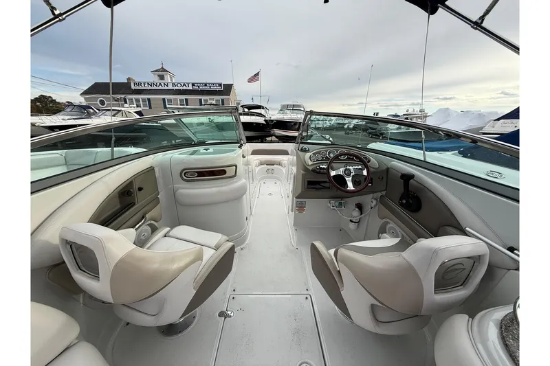Slide: The Image of 2013 Crownline Eclipse E6 boat interior with steering wheel and seating, docked at marina. - 7