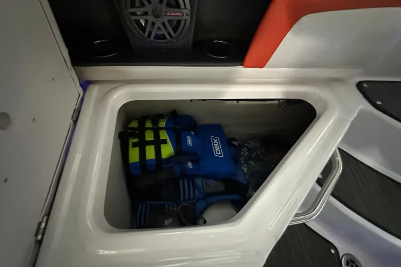 Slide: The Image of Storage compartment in 2017 Four Winns HD220 RS boat with life jackets and speaker. - 14