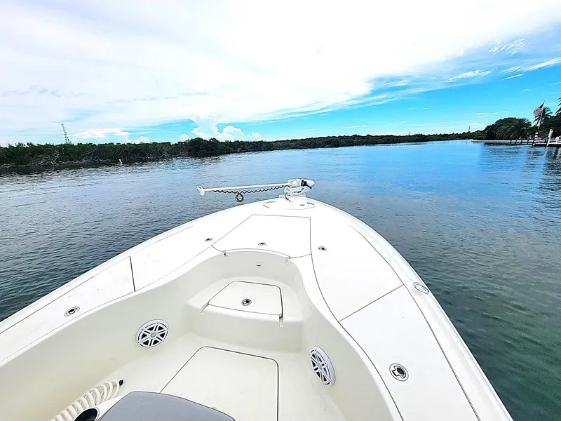 Slide: The Image of 2017 SeaVee 270Z boat on calm water with clear sky and lush shoreline. - 10