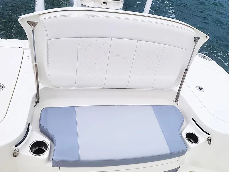 Slide: The Image of 2017 SeaVee 270Z boat seat with white and blue cushions, cup holders, and ocean backdrop. - 20