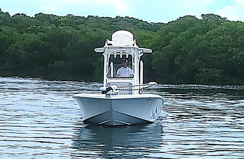 Slide: The Image of 2017 SeaVee 270Z boat navigating calm waters with lush green background. - 3