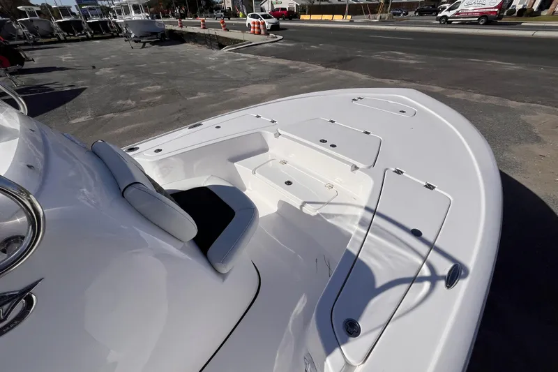 Slide: The Image of 2026 Tidewater 2110 Bay Max boat with spacious deck and seating, parked outdoors. - 9