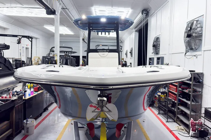 Slide: The Image of 2026 Tidewater 272 CC Adventure boat in a workshop, showcasing sleek design and modern features. - 10