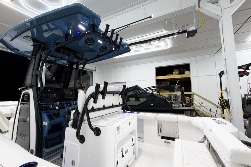 Slide: The Image of 2026 Tidewater 272 CC Adventure boat interior with modern controls and seating in a garage. - 11