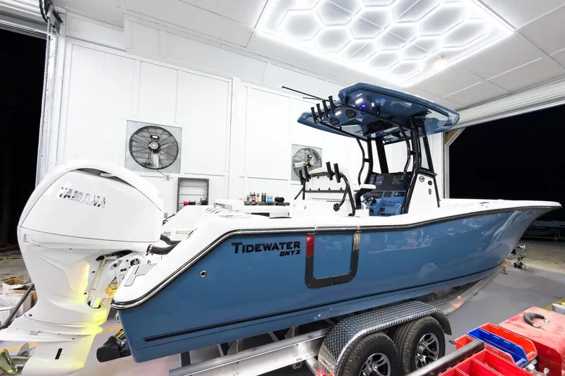 Slide: The Image of 2026 Tidewater 272 CC Adventure boat in a well-lit garage, featuring Yamaha engine. - 2