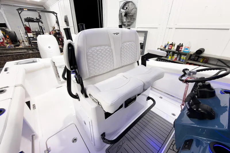 Slide: The Image of 2026 Tidewater 272 CC Adventure boat interior with white seating and modern controls. - 23