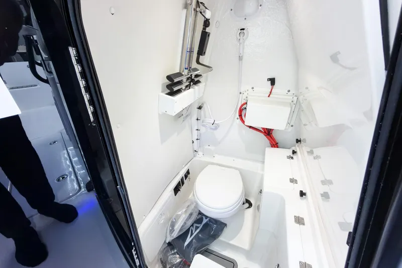 Slide: The Image of Interior of 2026 Tidewater 272 CC Adventure boat, featuring a compact marine toilet. - 39