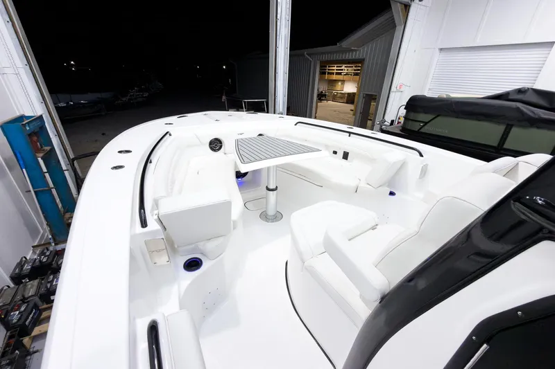 Slide: The Image of 2026 Tidewater 272 CC Adventure boat interior with seating and table in a well-lit garage. - 40