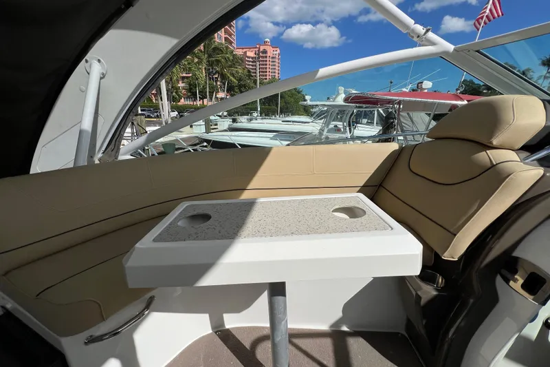 Slide: The Image of Interior of 2013 Cruisers Yachts 380 Express with seating and table, docked under blue sky. - 10