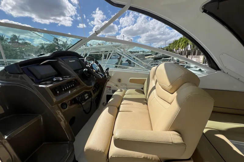 Slide: The Image of 2013 Cruisers Yachts 380 Express cockpit with beige seating and modern dashboard controls. - 11