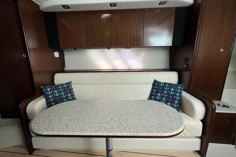 Slide: The Image of Interior of 2013 Cruisers Yachts 380 Express with white seating and anchor-themed pillows. - 18