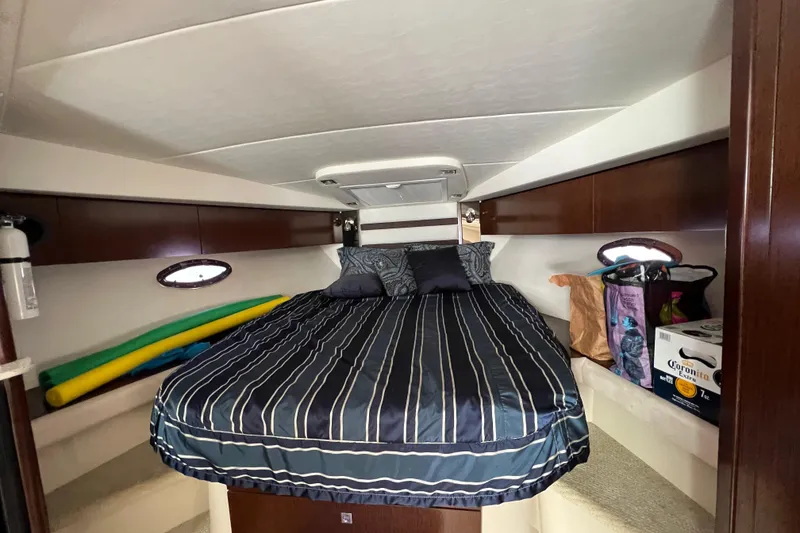 Slide: The Image of 2013 Cruisers Yachts 380 Express cabin with bed, storage, and portholes. - 20