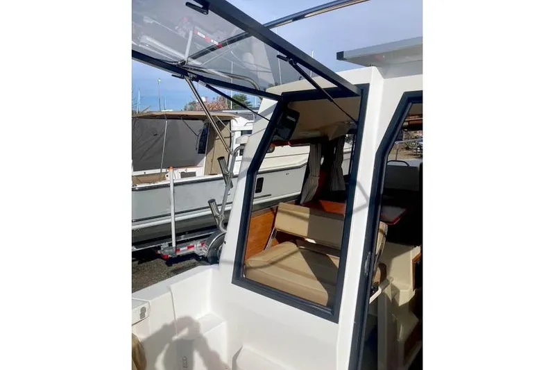 Slide: The Image of 2021 Ranger Tugs R-25 boat interior with open cabin door and seating area. - 13