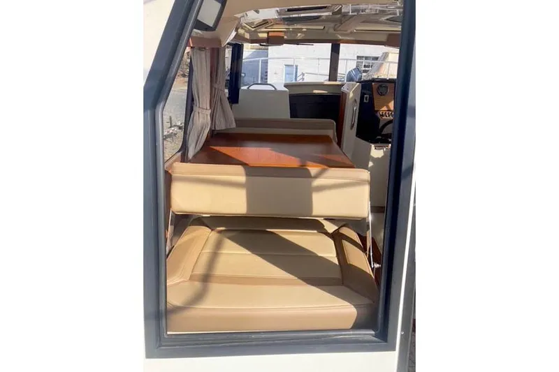 Slide: The Image of Interior view of 2021 Ranger Tugs R-25 boat with beige seating and wooden table. - 14
