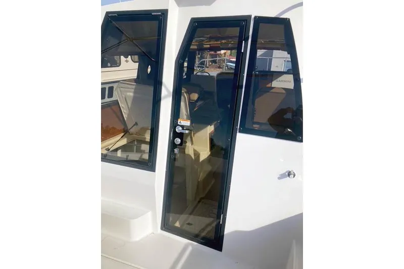 Slide: The Image of 2021 Ranger Tugs R-25 boat cabin door with sleek glass design. - 15