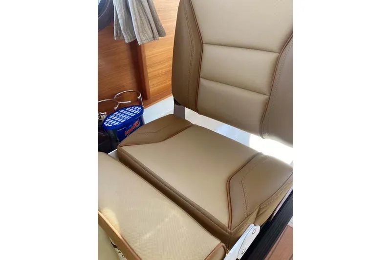Slide: The Image of 2021 Ranger Tugs R-25 interior seat with tan upholstery and wooden accents. - 23