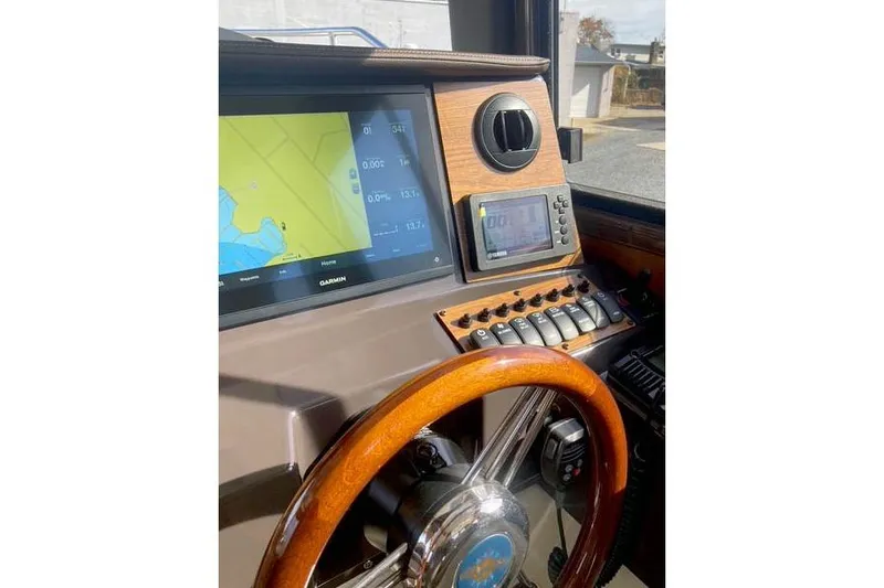 Slide: The Image of 2021 Ranger Tugs R-25 helm with Garmin navigation display and wooden steering wheel. - 26