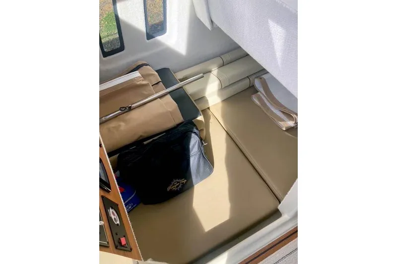 Slide: The Image of 2021 Ranger Tugs R-25 interior cabin with storage and seating area. - 29