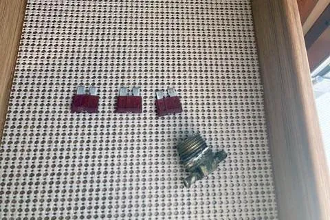 Slide: The Image of Three red fuses and a corroded component on a textured surface, Ranger Tugs R-25, 2021. - 39