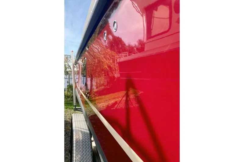 Slide: The Image of 2021 Ranger Tugs R-25 boat with glossy red exterior, side view. - 6