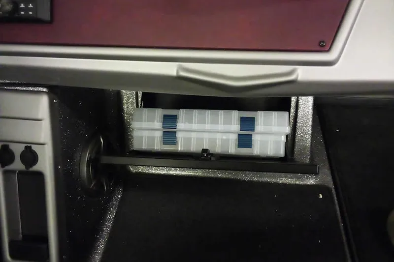 Slide: The Image of 2026 Ranger 1850MS Reata storage compartment with organized tackle boxes. - 26