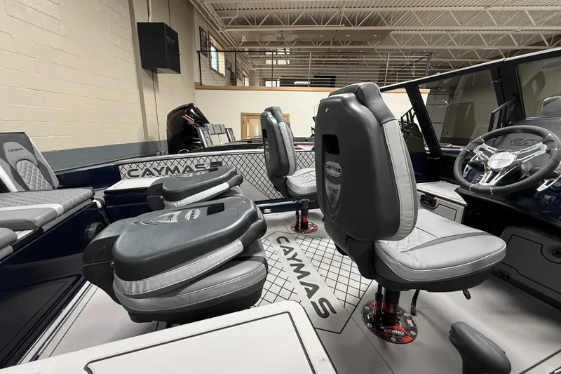 Slide: The Image of 2026 Caymas DV 22 boat interior with modern seating and steering wheel in showroom. - 13