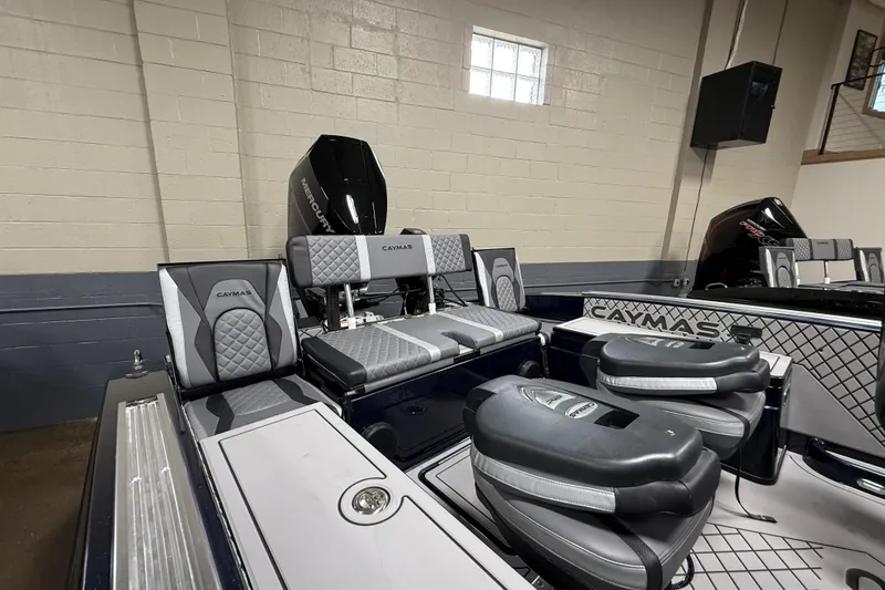 Slide: The Image of 2026 Caymas DV 22 boat interior with cushioned seating and Mercury outboard motor. - 14