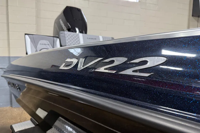 Slide: The Image of 2026 Caymas DV 22 boat with sleek design and metallic finish in showroom. - 17