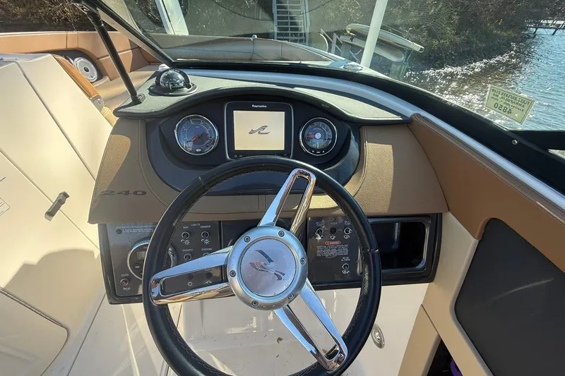 Slide: The Image of Steering console of a 2015 Sea Ray 240 Sundeck boat with gauges and controls. - 13