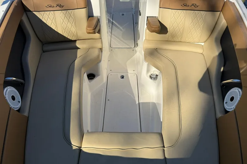 Slide: The Image of 2015 Sea Ray 240 Sundeck interior with beige seating and integrated speakers. - 19