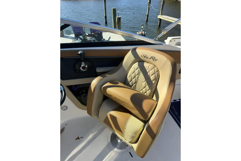 Slide: The Image of Captain's seat on 2015 Sea Ray 240 Sundeck boat, featuring luxurious tan upholstery. - 20